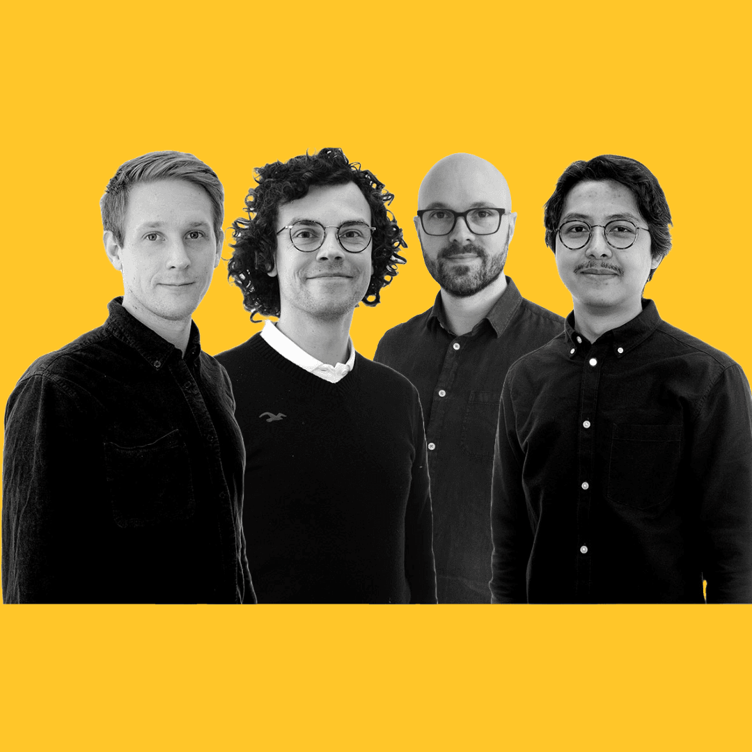 Four guys standing in front of yellow background